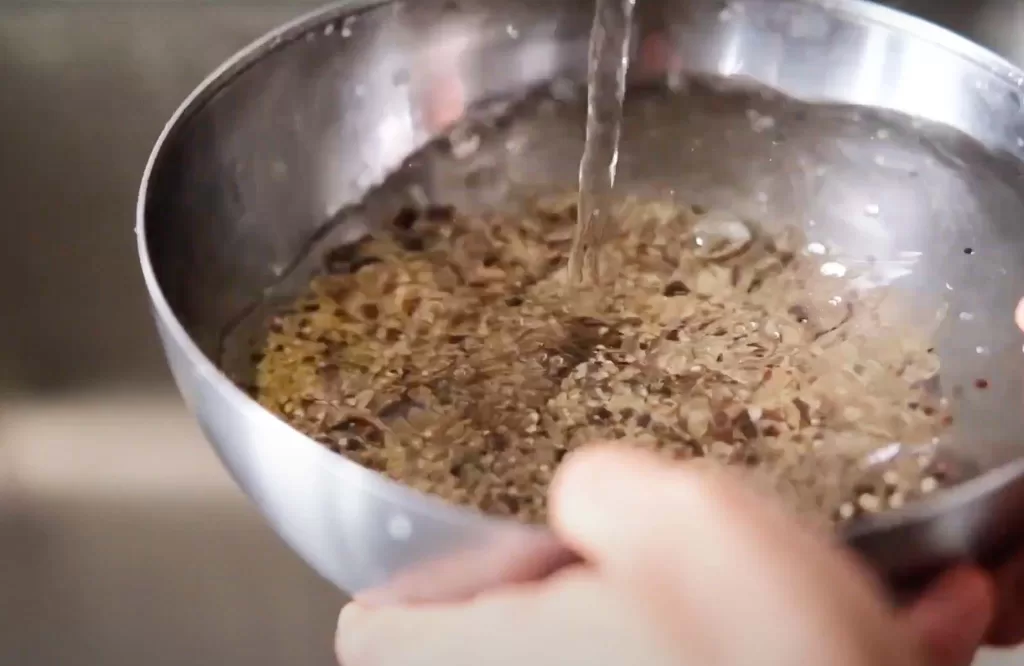 Filling water in a bowl of mixed grains to soak