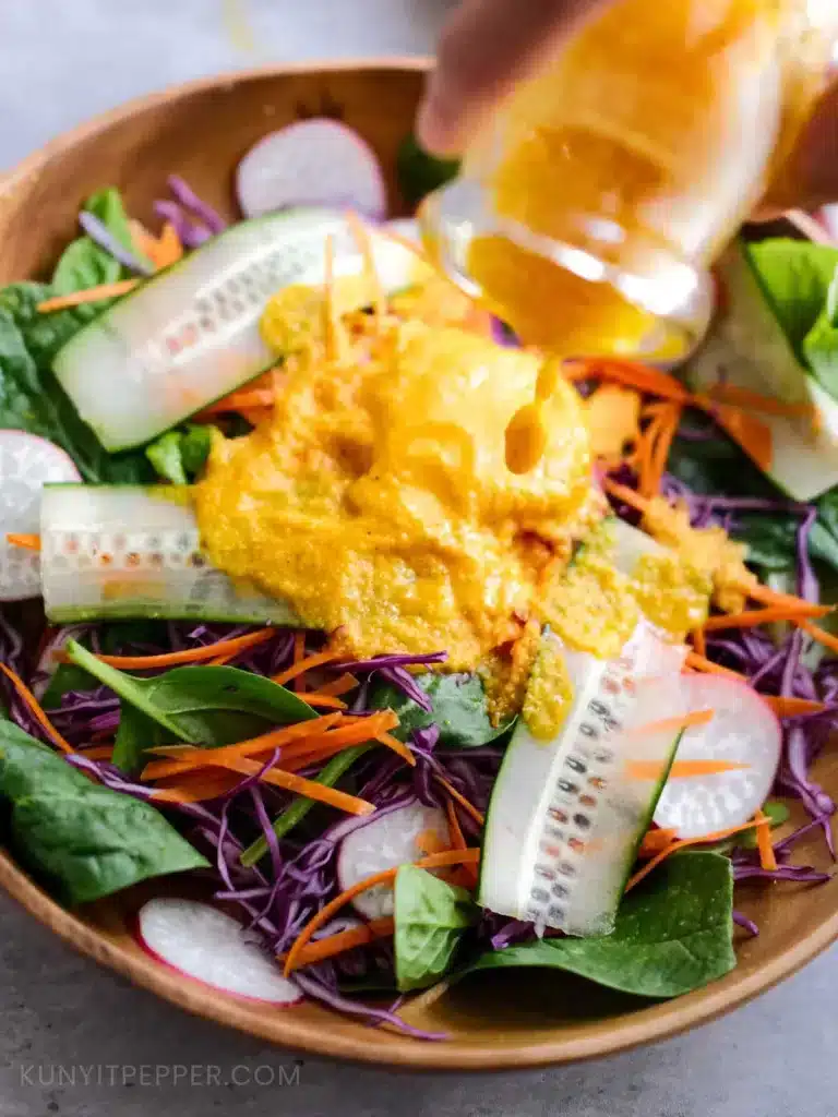 Pouring Japanese Carrot and Ginger Salad Dressing into Salad