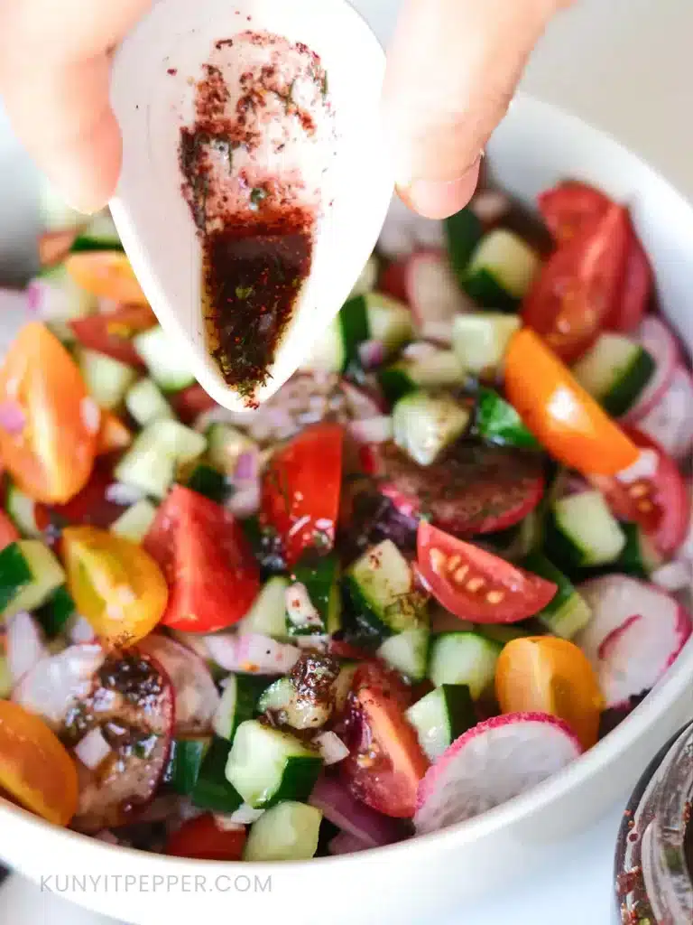 Pouring Sumac Sauce Salad Dressing on a bowl of Salad Shirazi