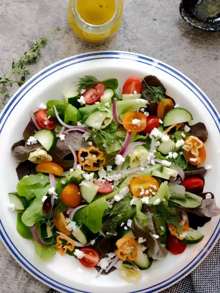 Top view of colorful salad next to salad dressing