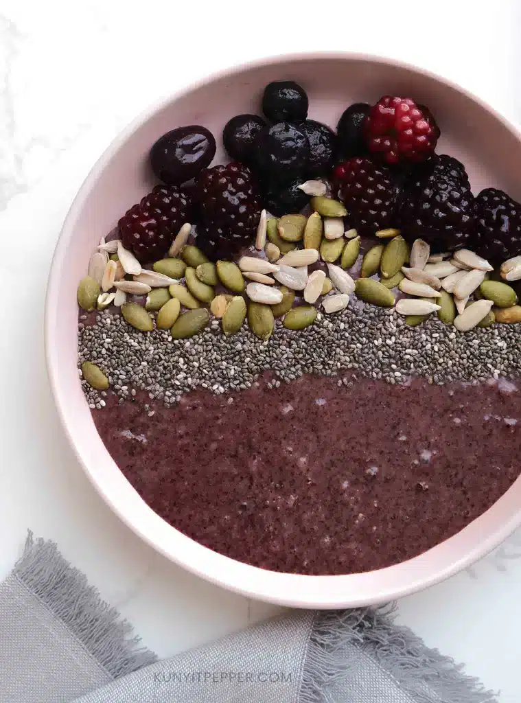 Black rice pudding acai-bowl-style with berries and seeds