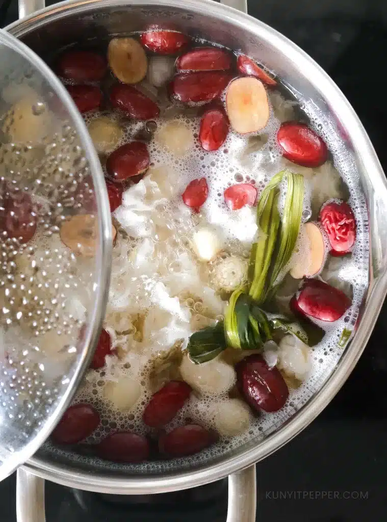 Simmering lotus seed sweet soup ingredients in a pot