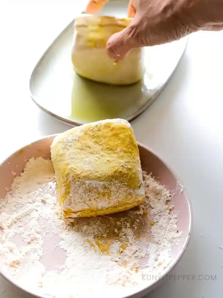 Coating firm tofu with olive oil and corn starch