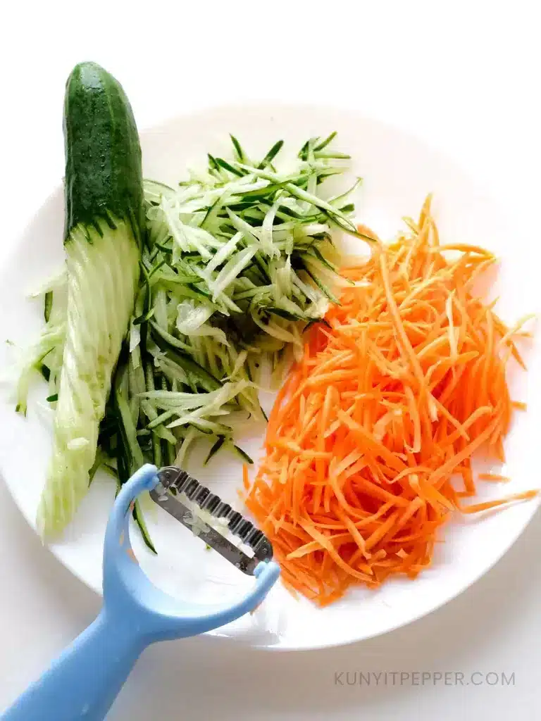 Julienne cut carrot and cucumber next to Julienne's cutter