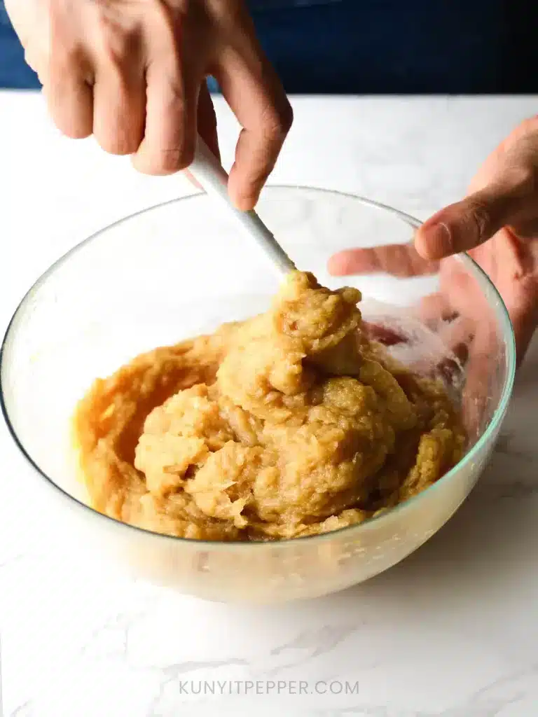 Mixing lemongrass chicken meatballs ingredients in a bowl with spatula