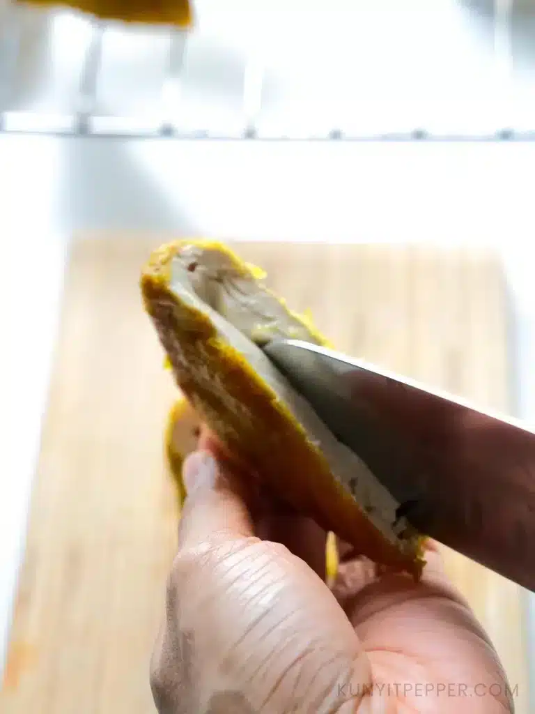 running the tip of knife into inner part of diagonal cut hard tofu