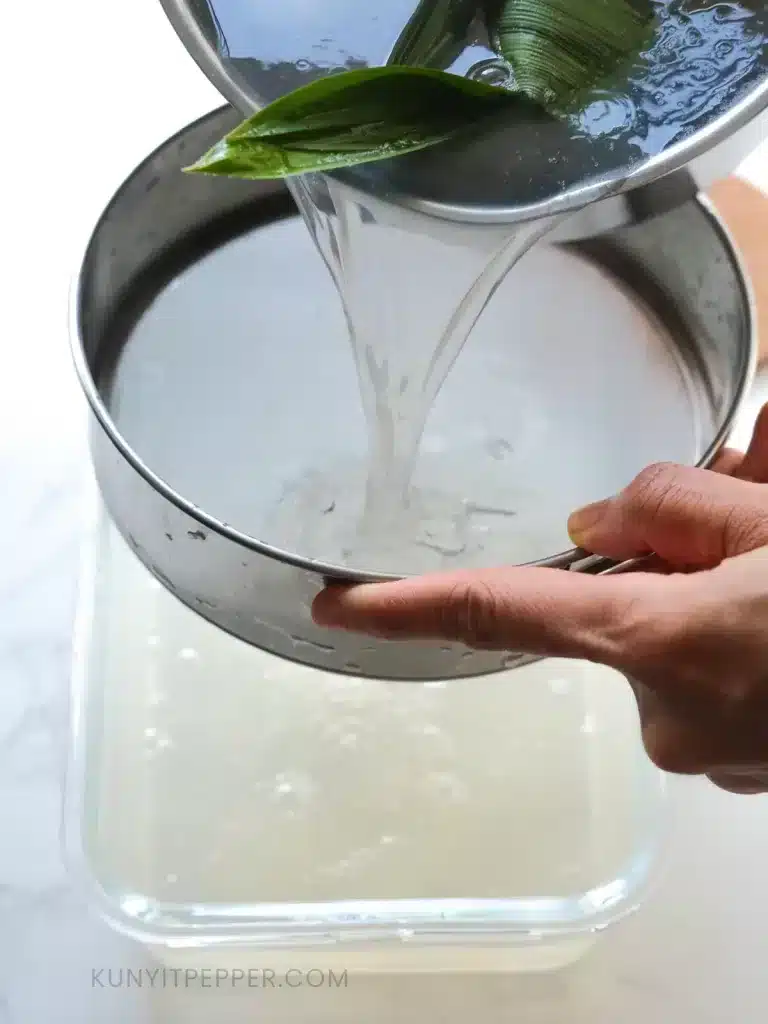 Pouring the solution in container through a fine mesh strainer