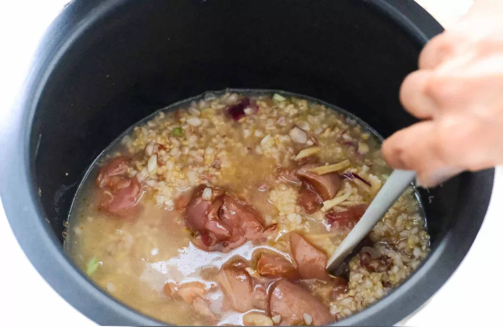 Stirring all ingredients of multigrain chicken congee in a pot