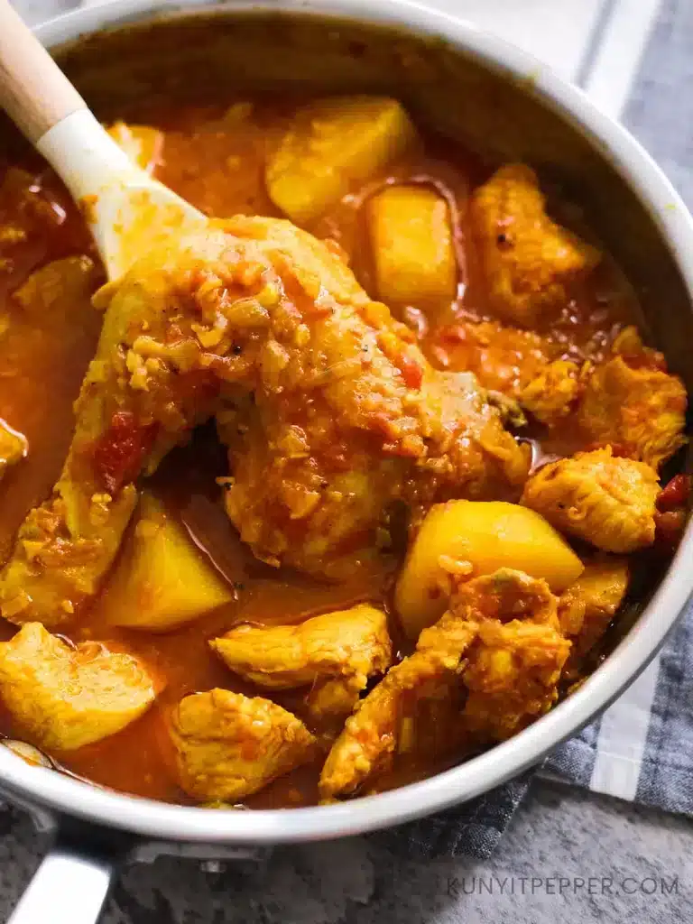 Scooping Saffron Chicken Leg in a pan