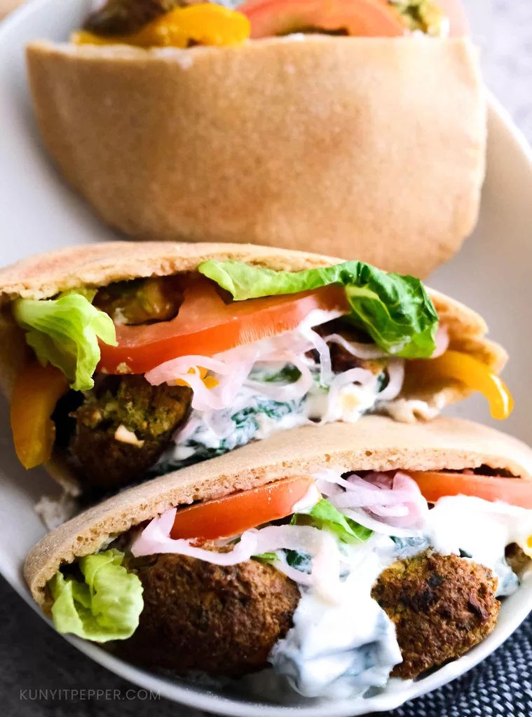 Falafel stuffed in whole wheat pita bread layered with vegetables and creamy Greek yogurt sauce
